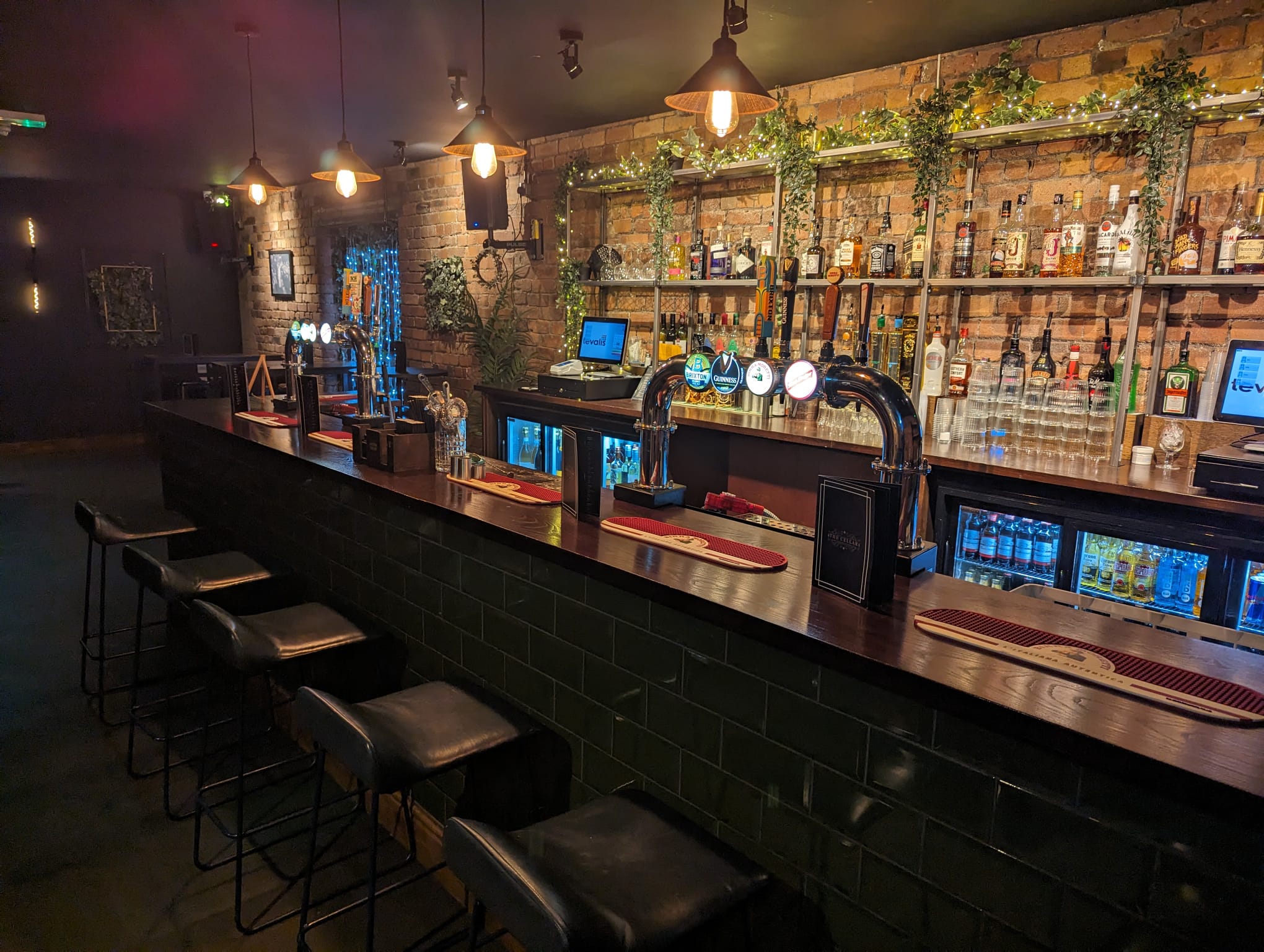 The Cellar — atmospheric dark green bar with pendant lighting