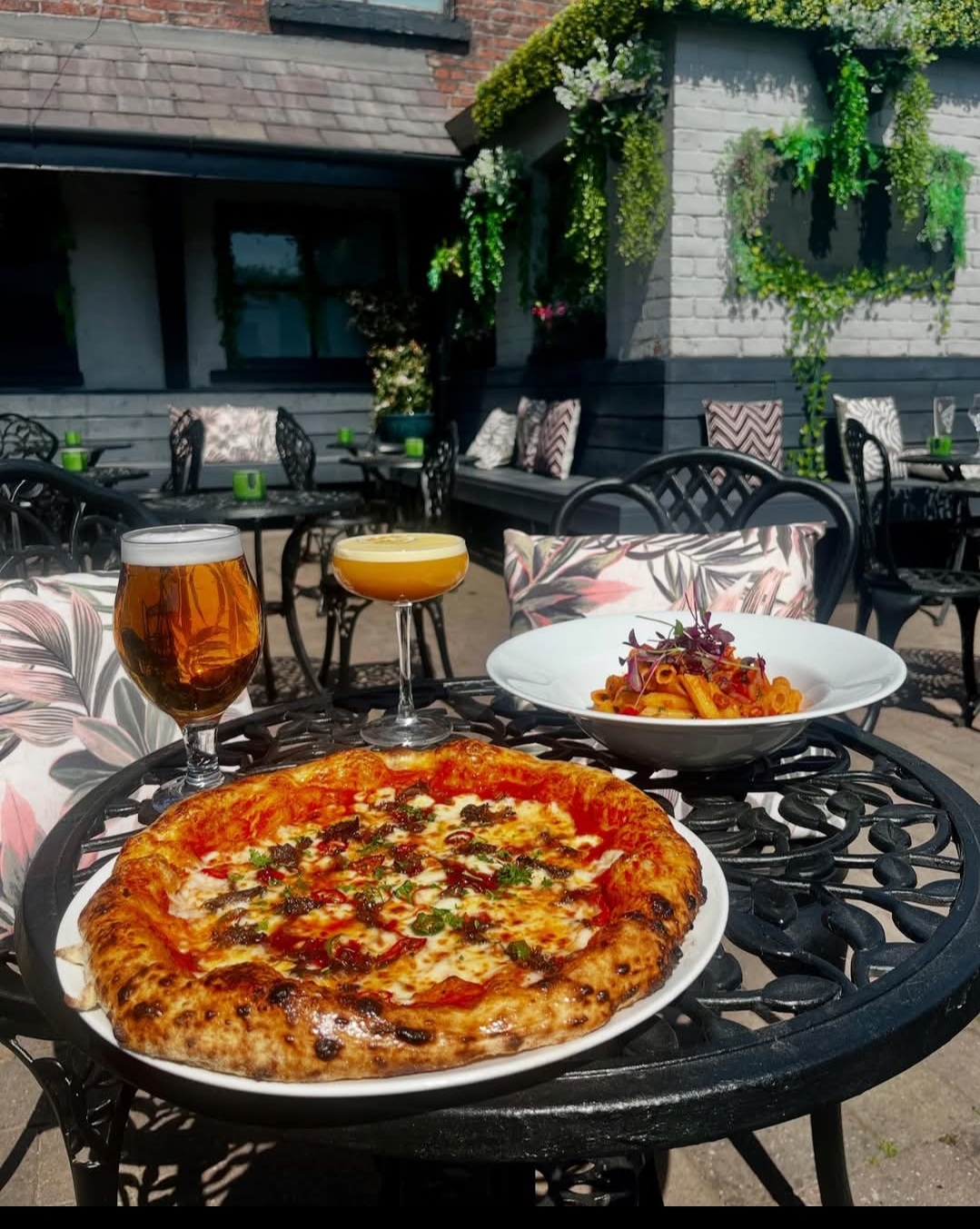 Pizza and cocktails on the rear terrace at Verona Kitchen & Bar — ivy-covered walls