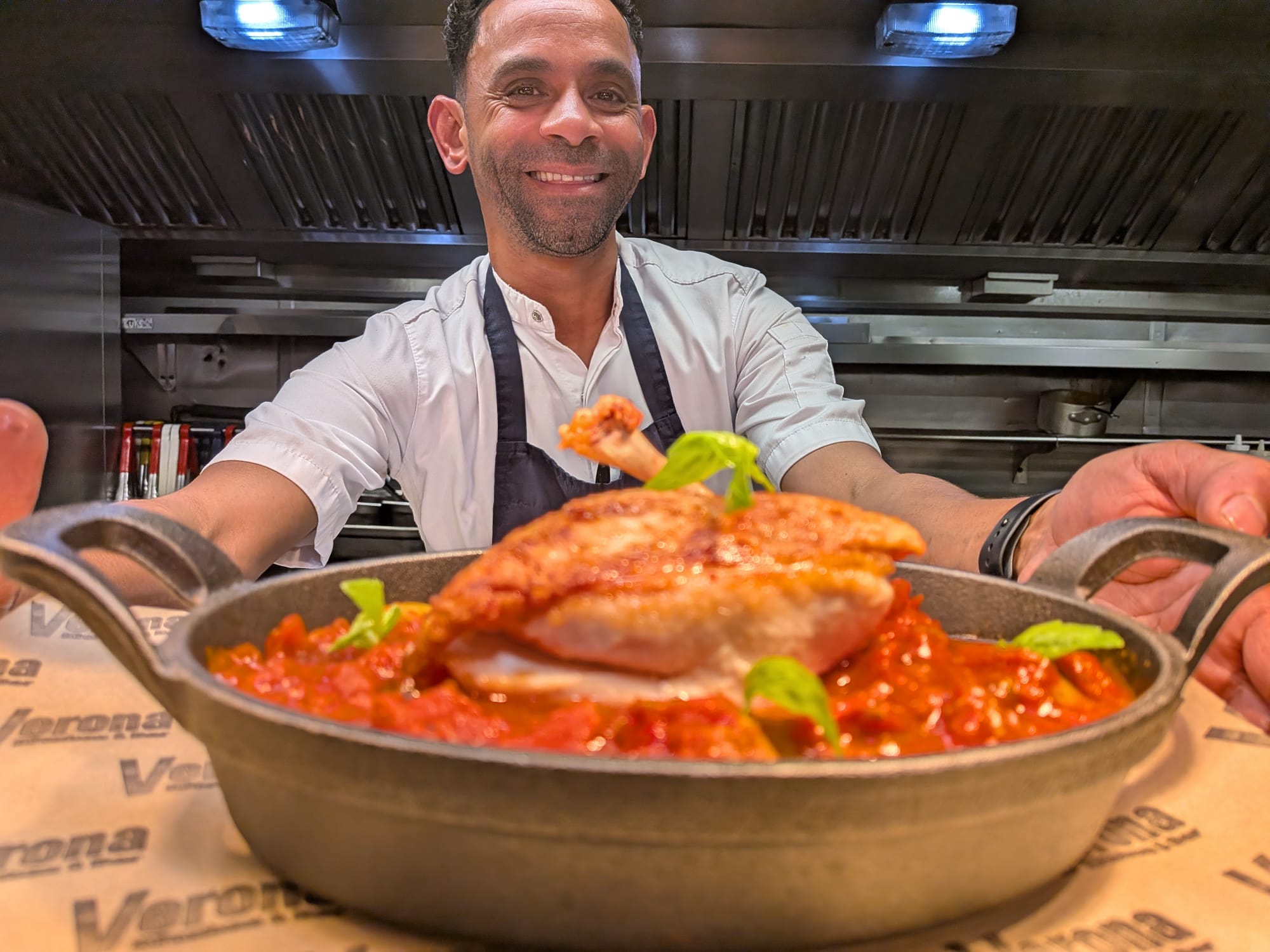 Head chef presenting a signature dish at Verona Kitchen & Bar